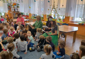 Nauczycielki siedzą przed dziećmi, czytają z podziałem na rolę opowiadanie.